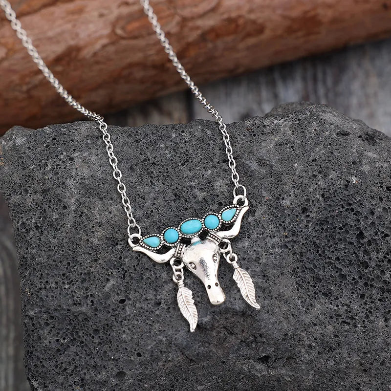 Silver necklace with turquoise bull head and feather charms