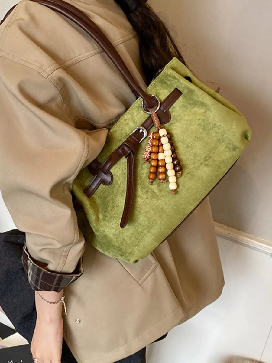 Green suede tote bag with beaded tassel detail and leather straps