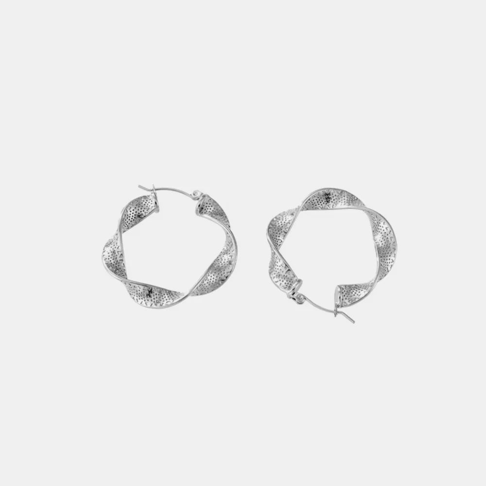 Textured spiral hoop earrings in silver with a twisted design and subtle dot pattern.