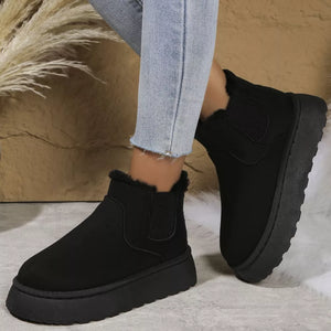 Black suede round toe platform ankle boots with fur trim and elastic gore.