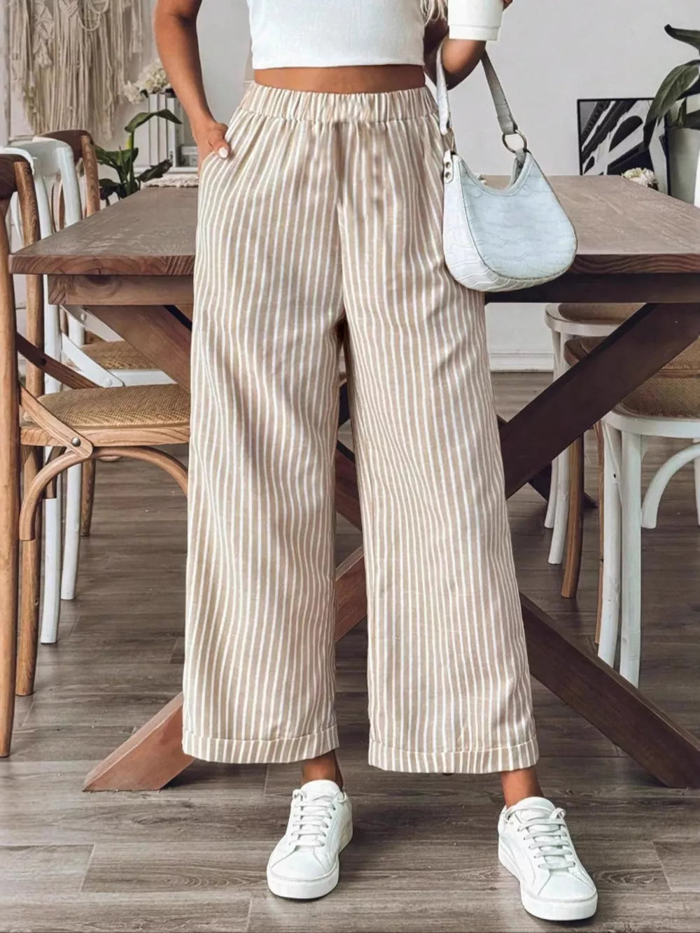 Chic high-waisted striped wide-leg pants in beige and white, with a relaxed fit.