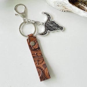 Western keychain with brown tooled leather strap and bull skull charm with crystal accents.
