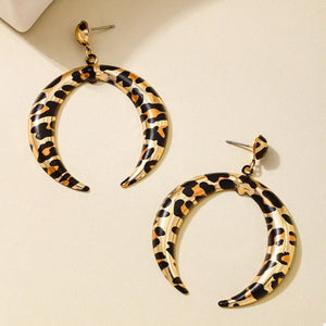 Crescent dangle earrings in gold with leopard print pattern.