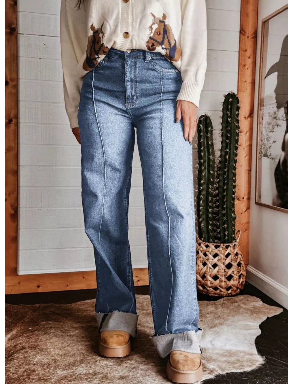 Light blue denim wide-leg jeans with buttoned pockets and contrast stitching.