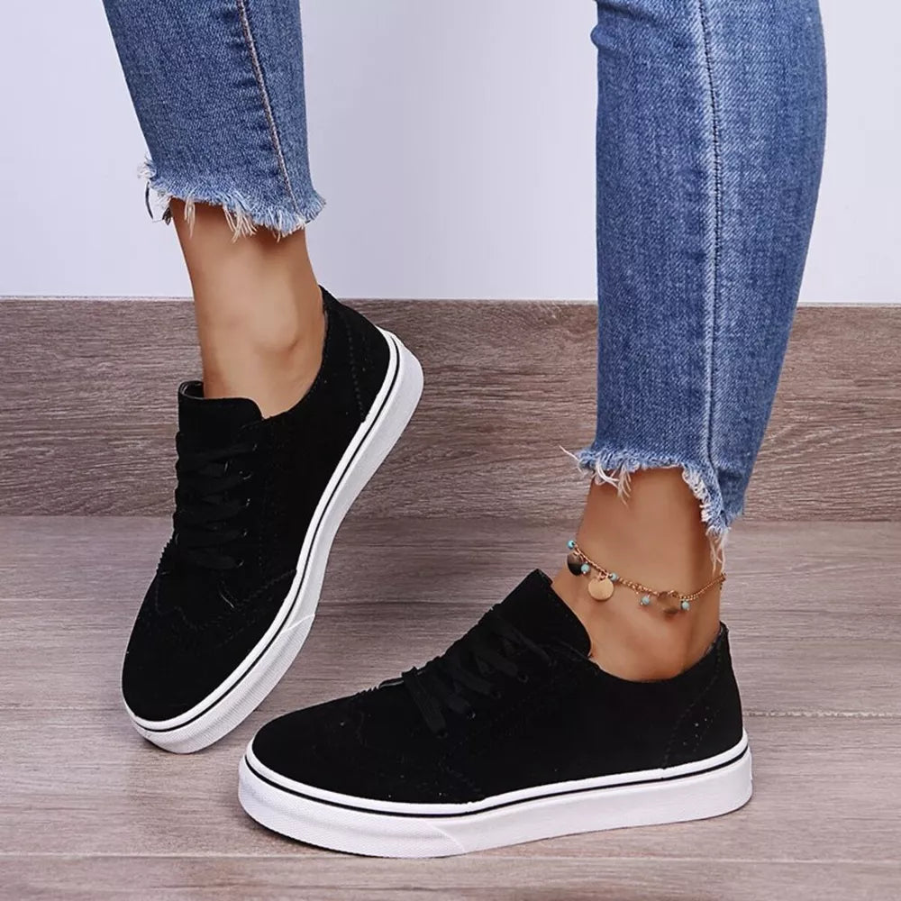 Black matte finish lace-up sneakers with white soles and wingtip detail.