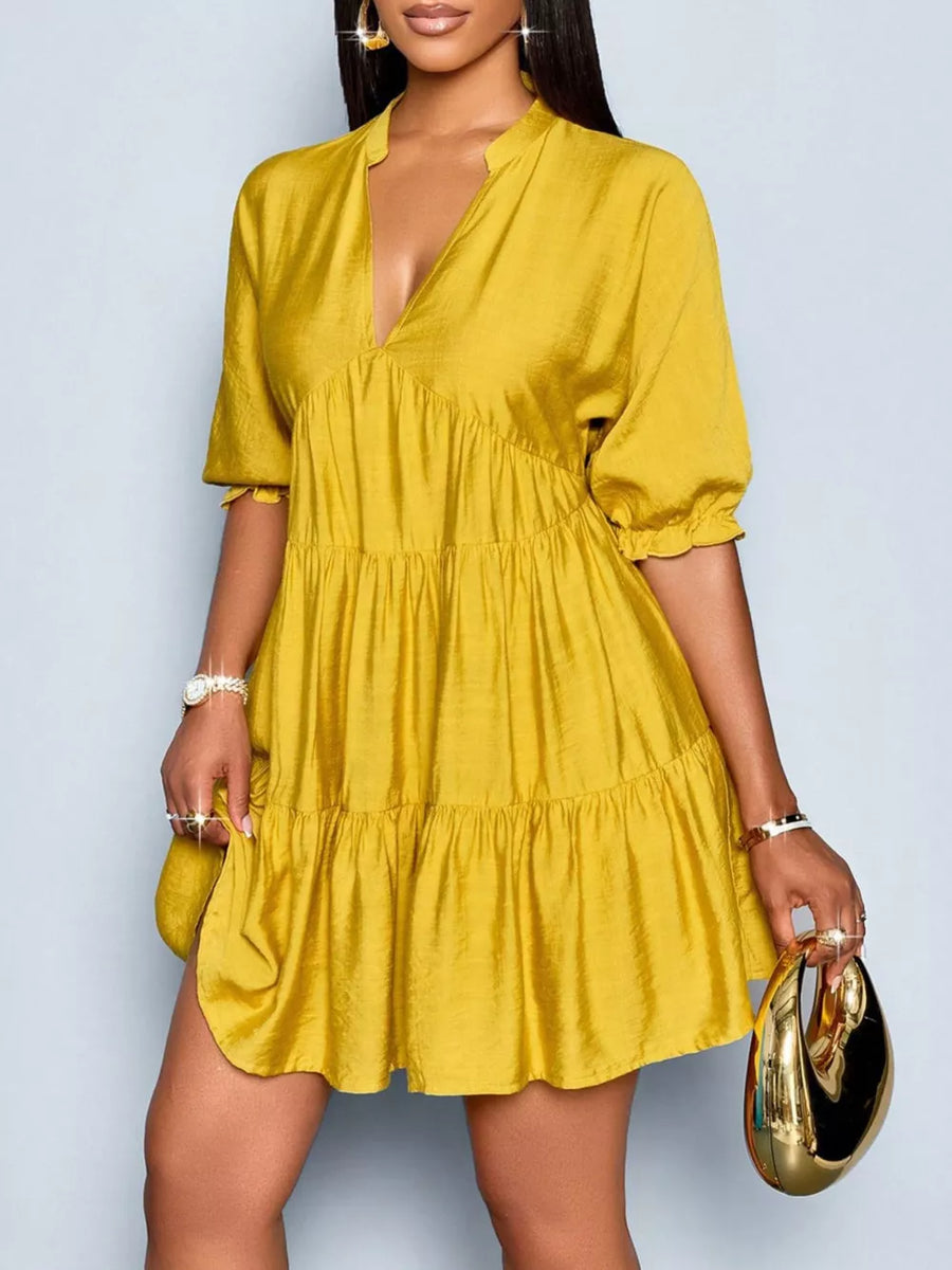 Yellow tiered mini dress with notched V-neck and short puff sleeves.