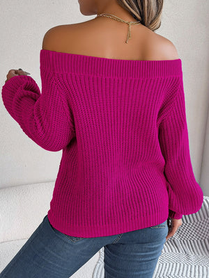 Open-knit off-shoulder sweater in cerise with voluminous sleeves and ribbed texture.