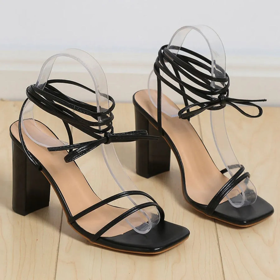 Black lace-up square toe block heels with ankle straps.