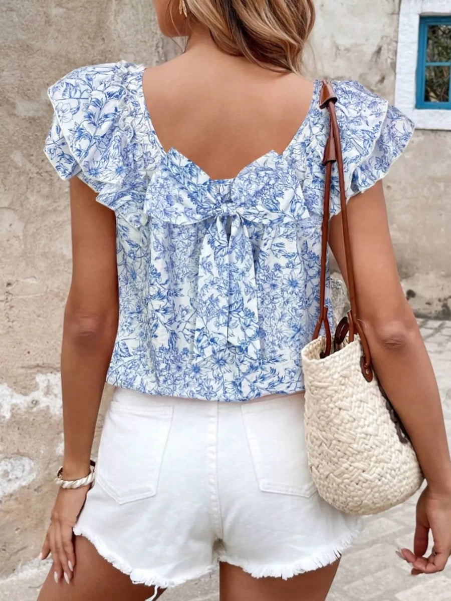 Blue floral ruffle blouse with a bow tie back and short sleeves.