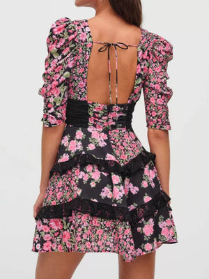Ruched floral tie-front dress with black lace trim and tiered skirt.