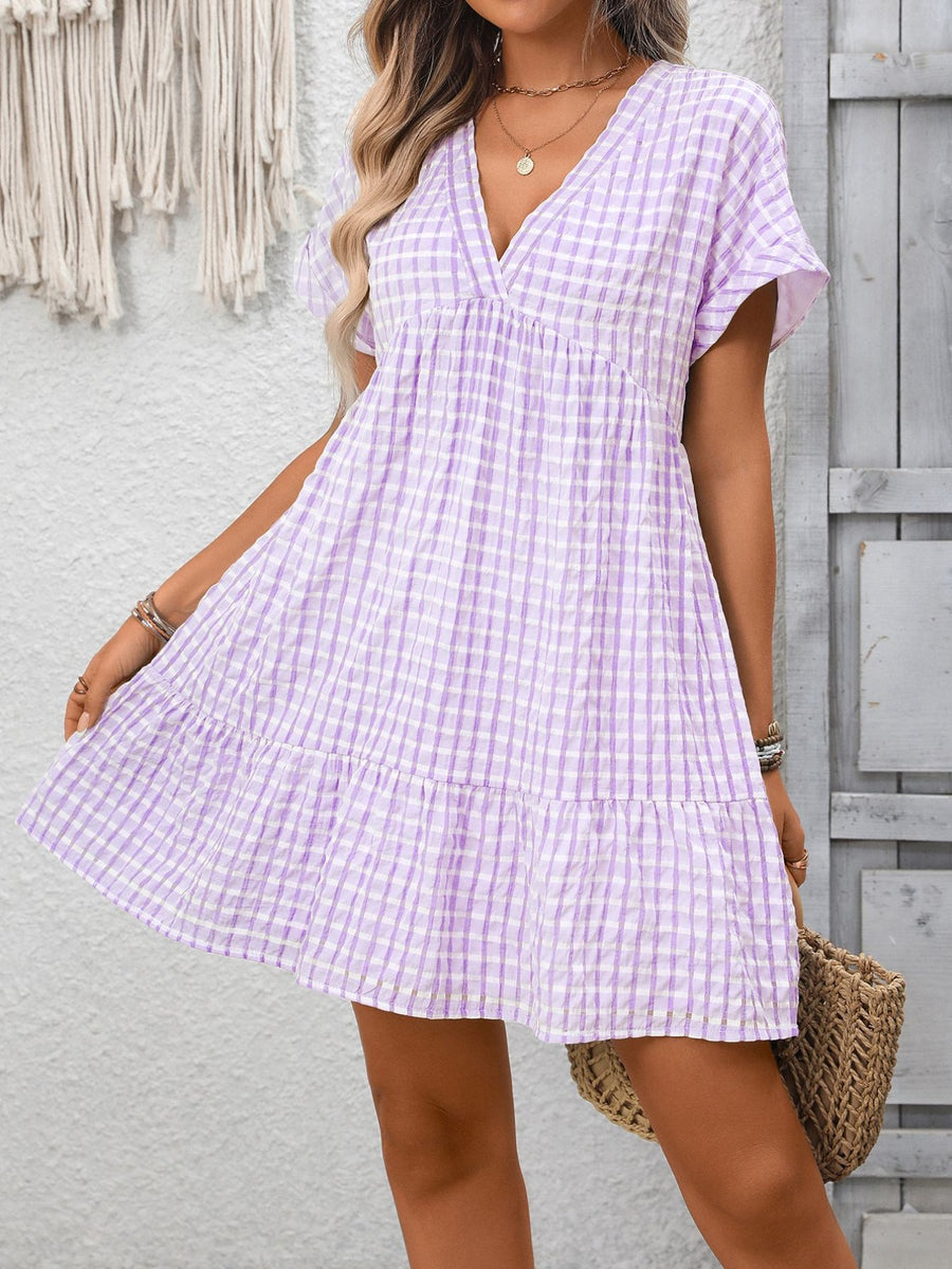 Plaid V-neck mini dress in light purple with short sleeves and tiered skirt.