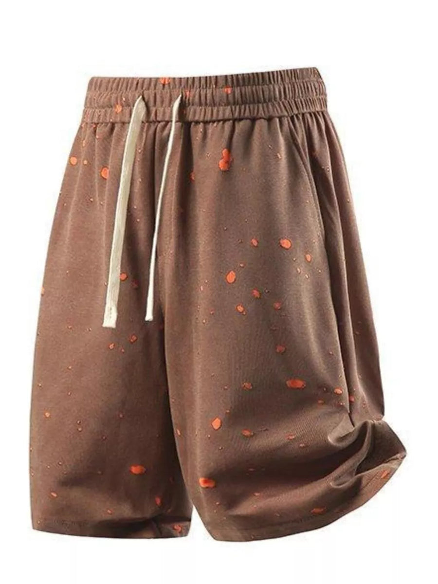 Brown relaxed fit shorts with orange splatter pattern and drawstring