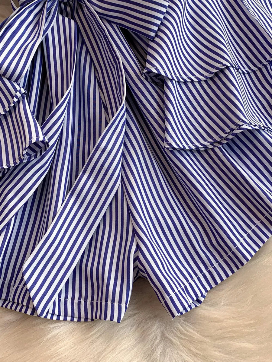 Blue and white striped romper with ruffles and a bow detail.