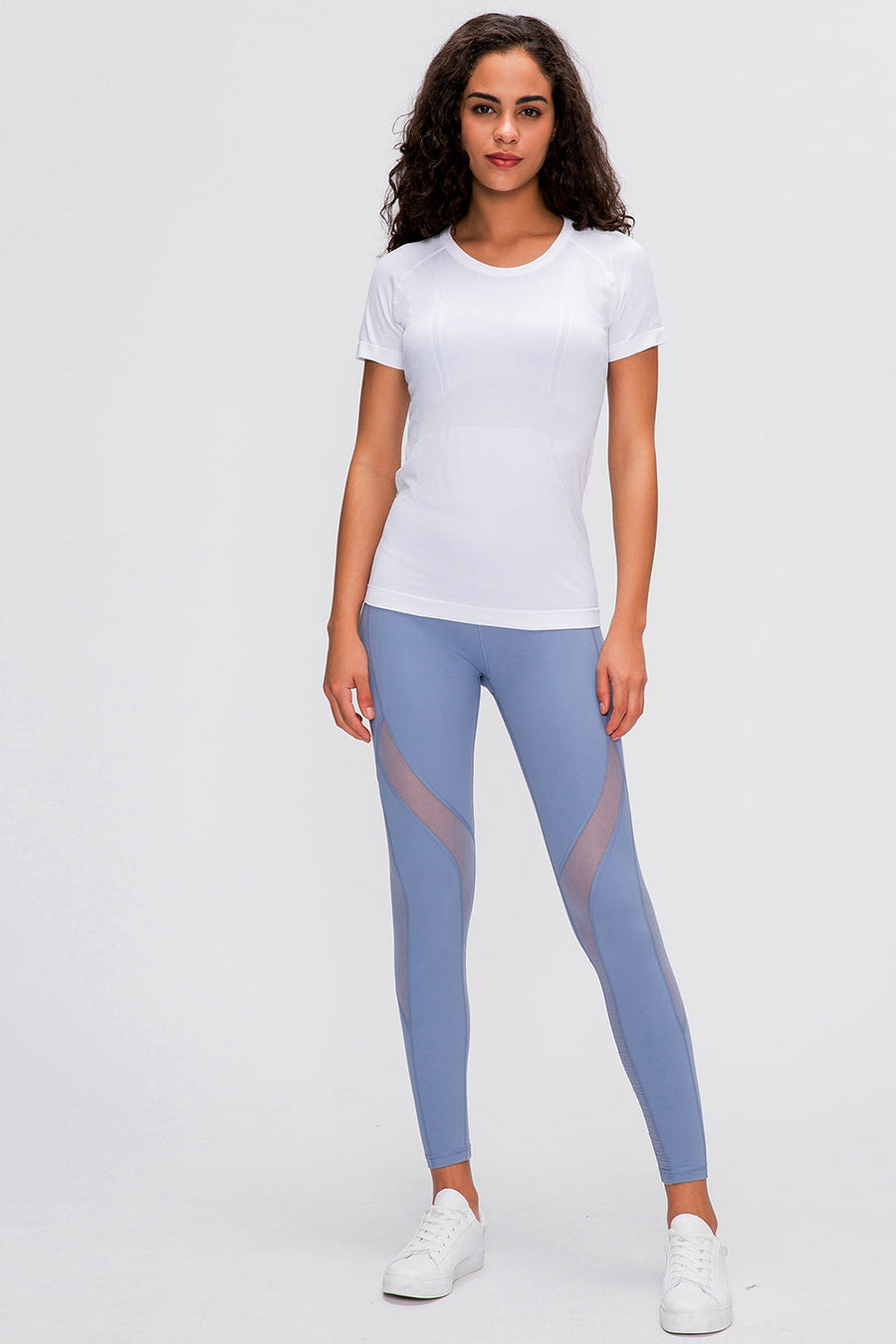 White seamless activewear tee with short sleeves and crew neck, paired with blue mesh panel leggings.