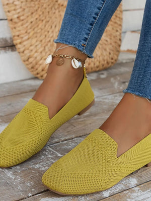 Mustard knit ballet flats with a textured pattern and a low heel.