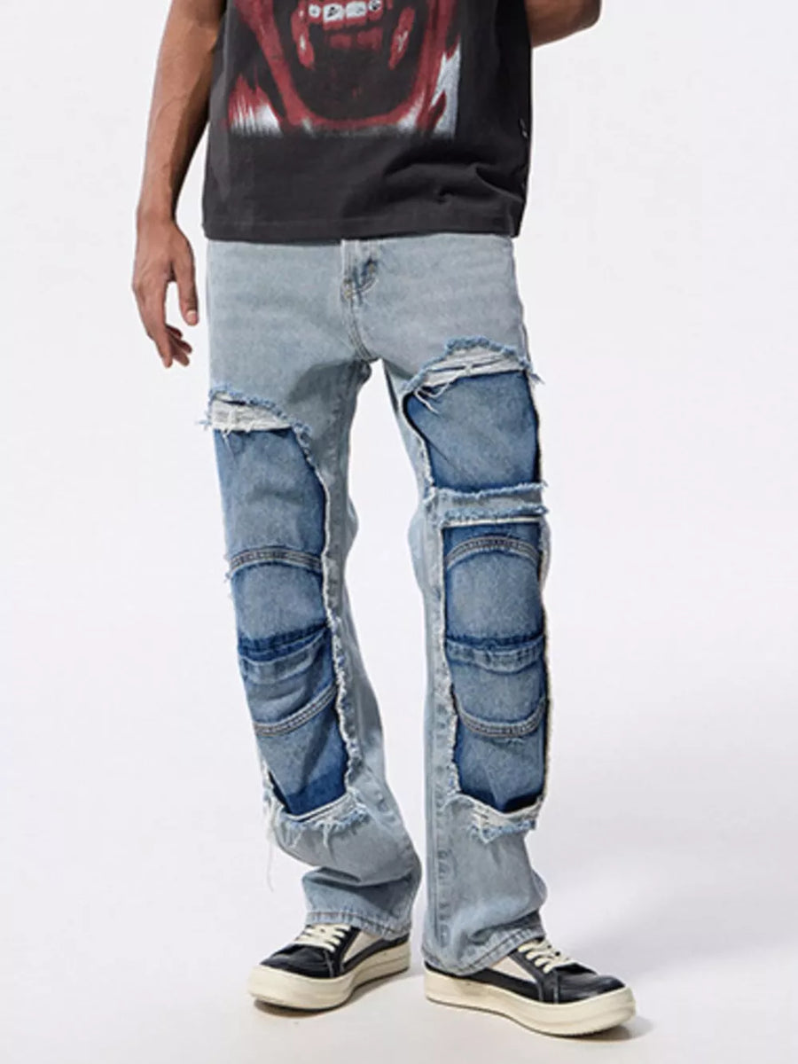 Men's light wash distressed patchwork jeans with ripped details and layered panels.