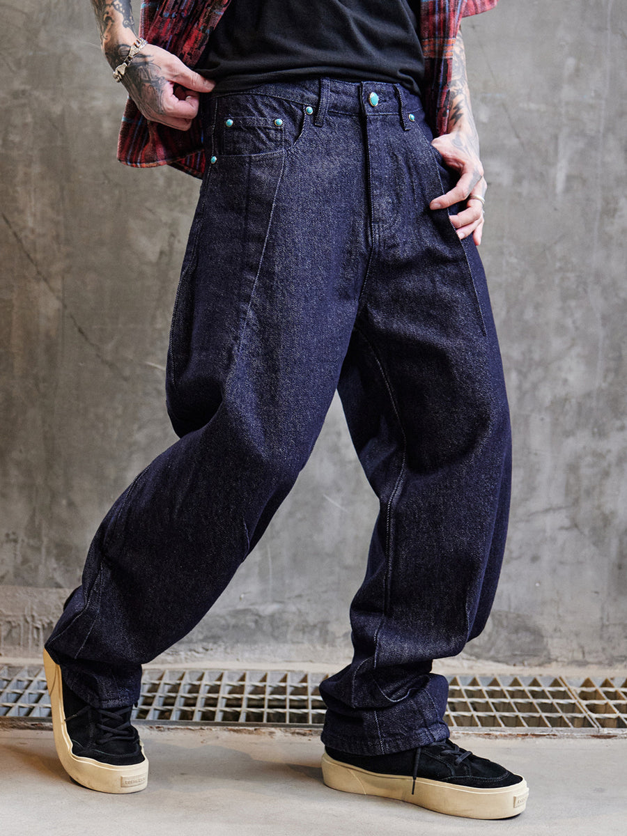 Men's wide leg indigo jeans in dark blue cotton denim with turquoise button details.
