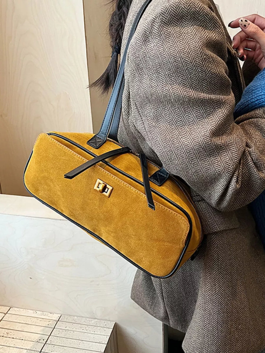 Premium suede shoulder bag in mustard yellow with gold clasp and black trim