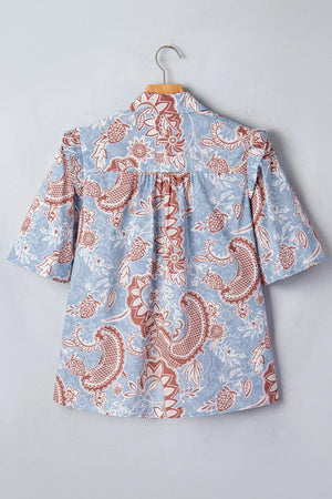 Blue cotton button-up shirt with a floral paisley print and ruffled sleeves.