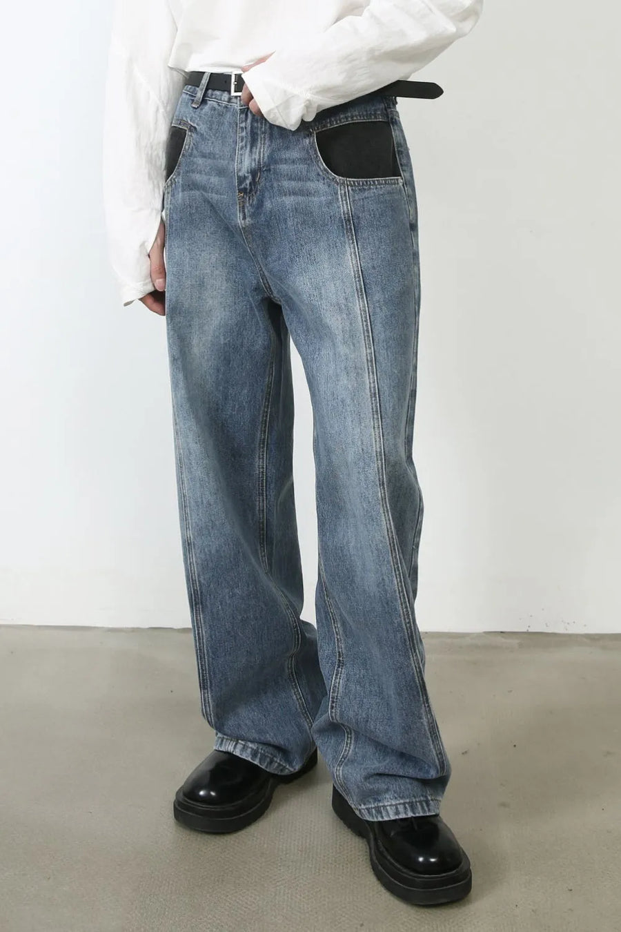 Panel seam denim trousers in medium wash with black pocket details and a relaxed fit.