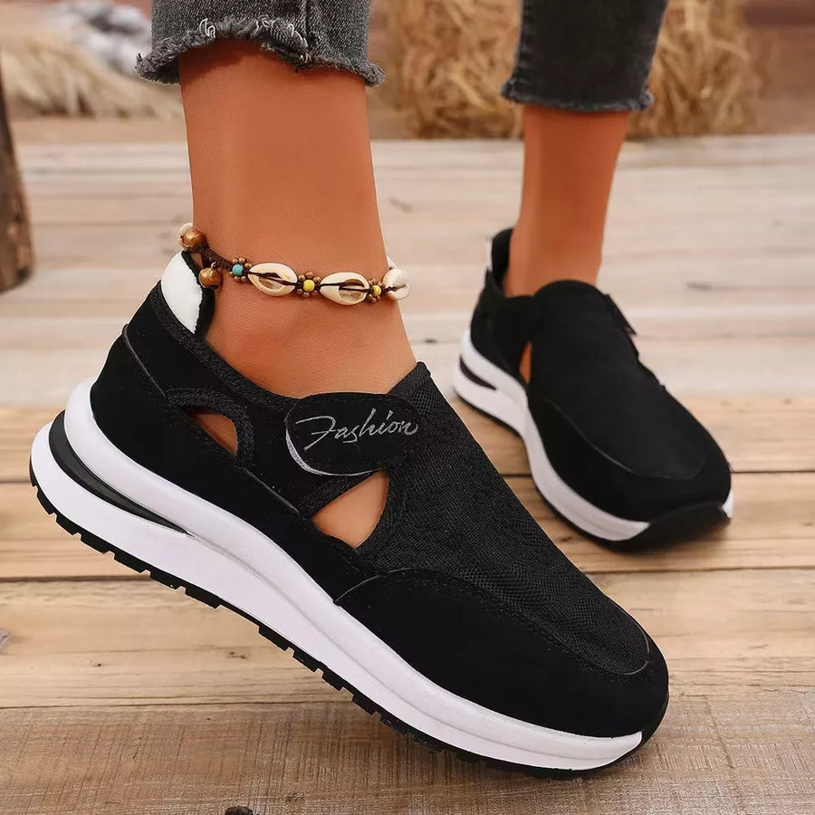 Black breathable cutout slip-on sneakers with white sole and "Fashion" detail.