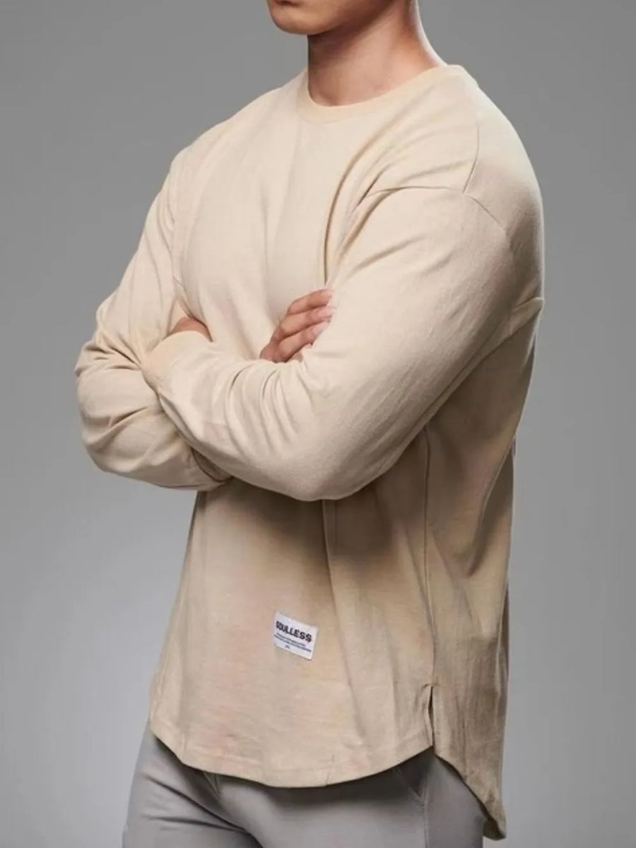 Khaki oversized long sleeve t-shirt with curved hem and side slits, featuring a small label detail.