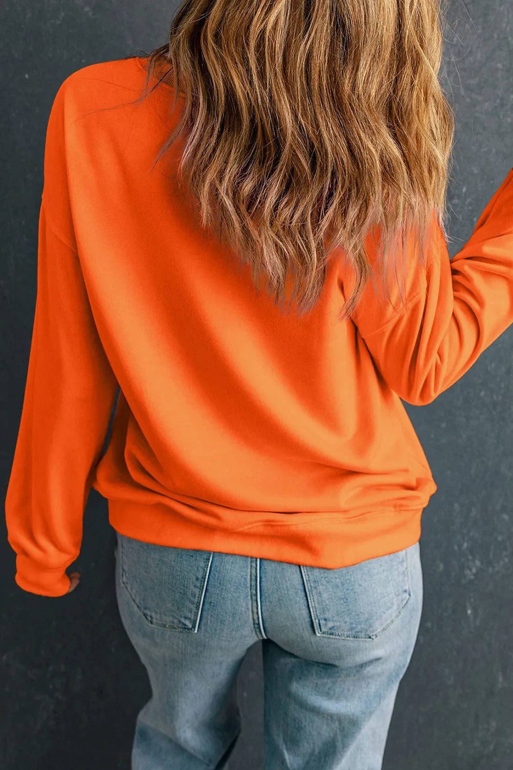 Orange crewneck sweatshirt with long sleeves and a relaxed fit.