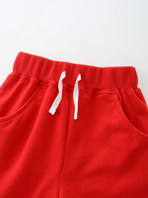 Red cotton toddler shorts with elastic waistband, drawstring, and pockets.