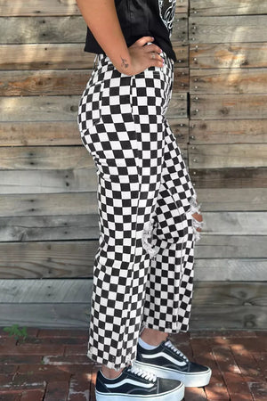 Checkerboard distressed cropped jeans in black and white denim with ripped knees.