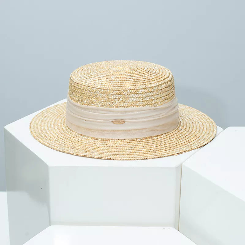 Beige straw boater hat with sheer ribbon band and oval logo detail