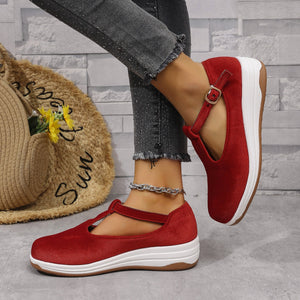Red T-bar flat slip-ons with adjustable ankle strap and white sole.