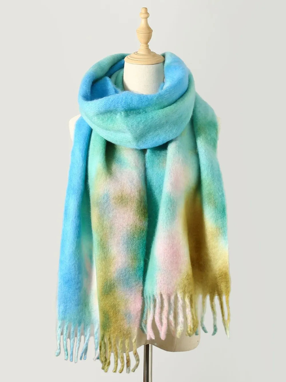 Watercolor wash fringe scarf in pastel blue, green, pink, and yellow hues.