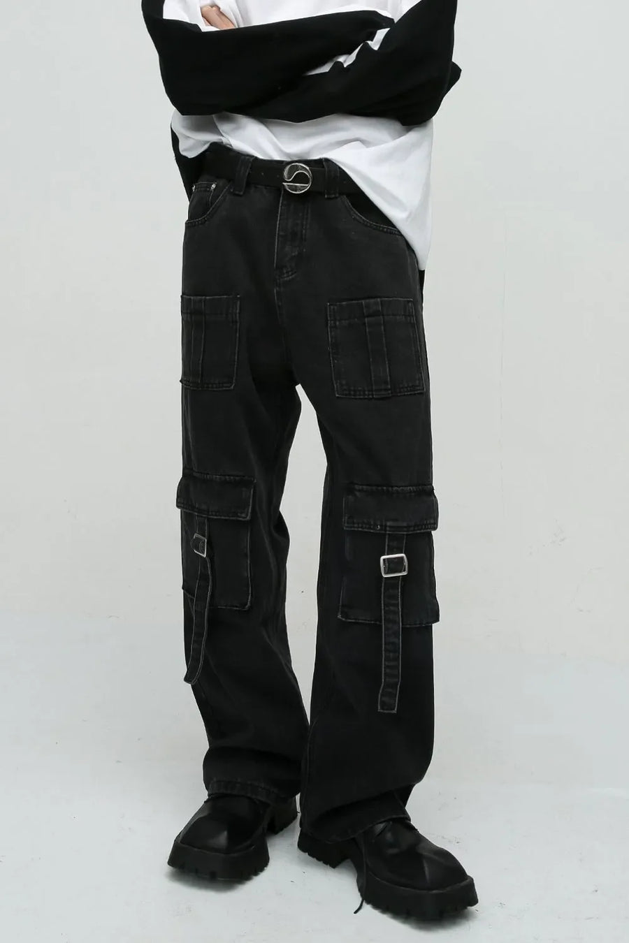 Dark utility denim cargo pants with buckle pockets and a statement belt.
