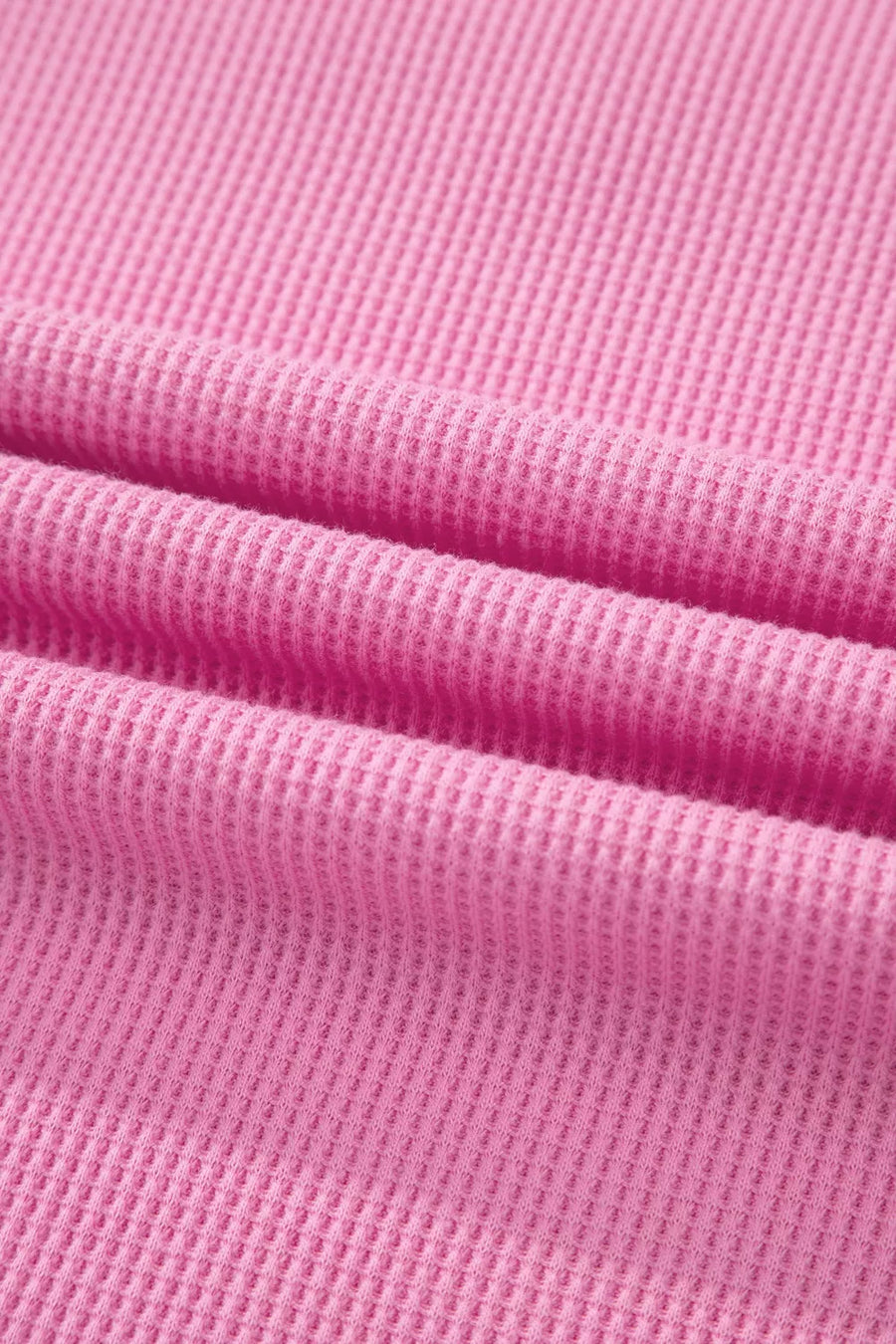 Pink waffle knit polyester t-shirt with a pocket detail and textured fabric.