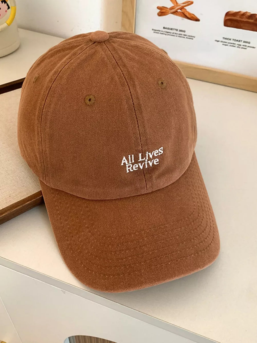 Chocolate brown baseball cap with white embroidered "All Lives Revive" text.