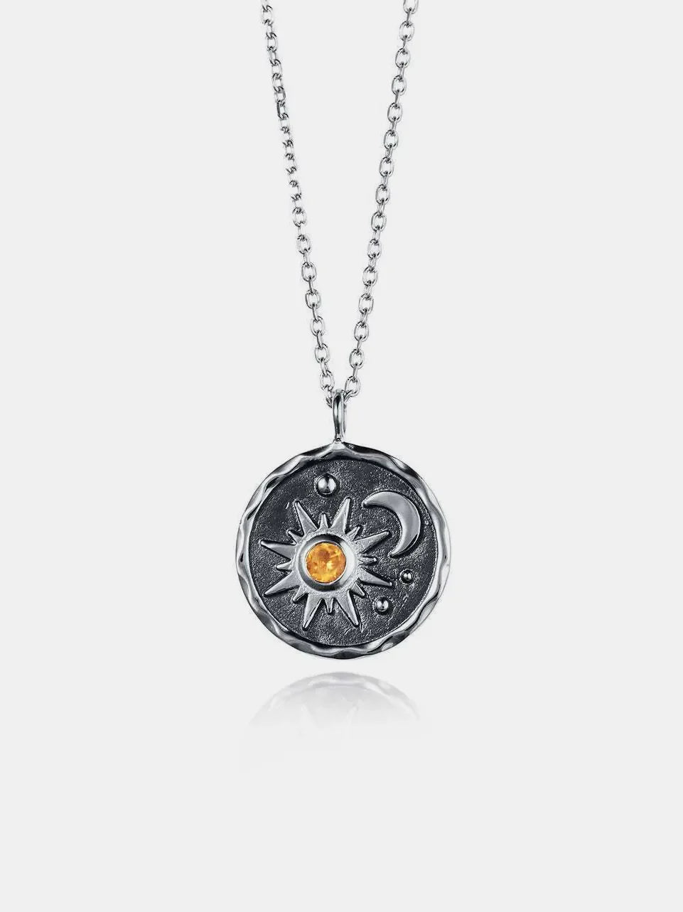 Silver celestial medallion pendant with sun, moon, and zircon detail on a chain.