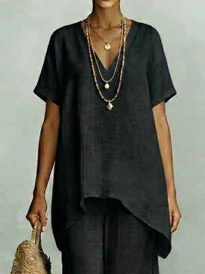 Black linen v-neck short sleeve tunic with layered necklaces and straw bag