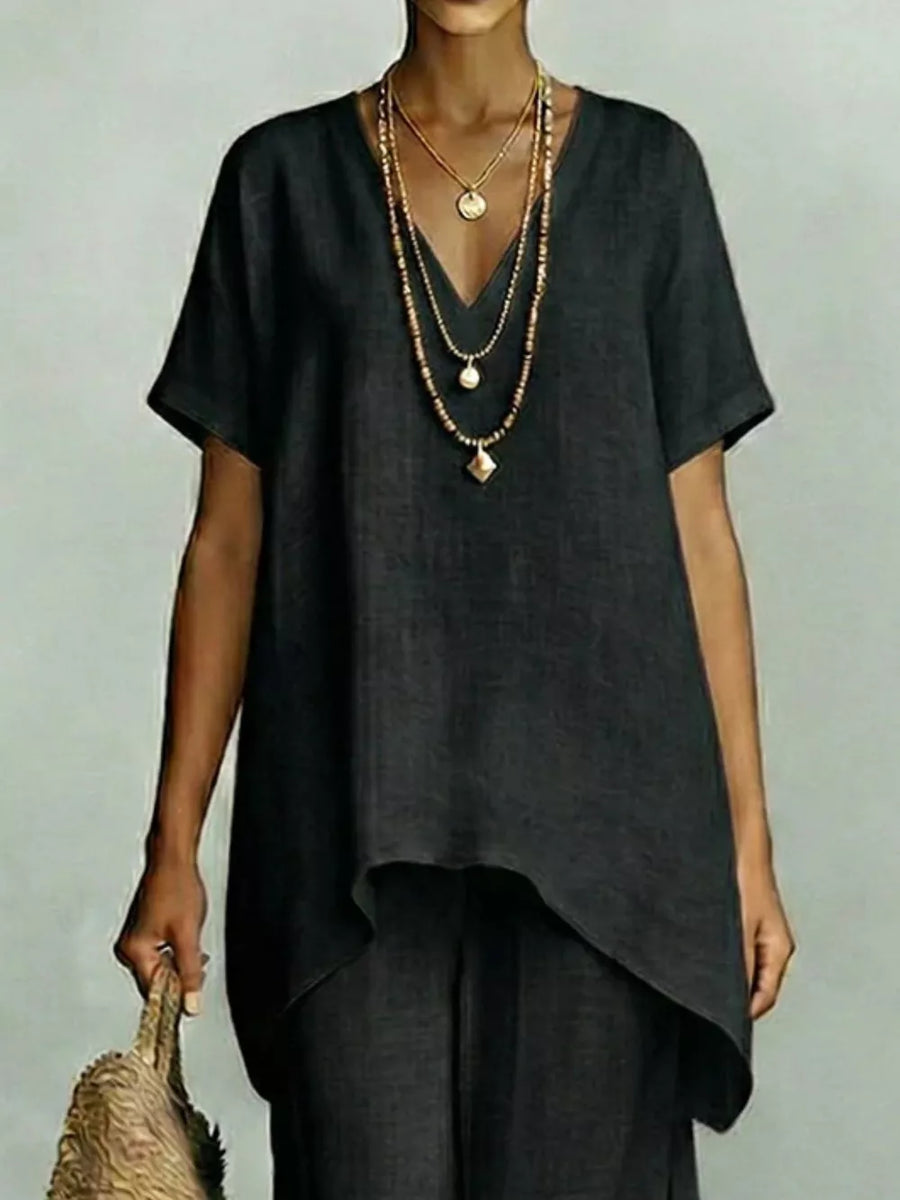 Black linen v-neck short sleeve tunic with layered necklaces and straw bag