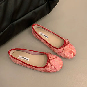 Pink floral bow slip-on flats with red trim and 3D texture.