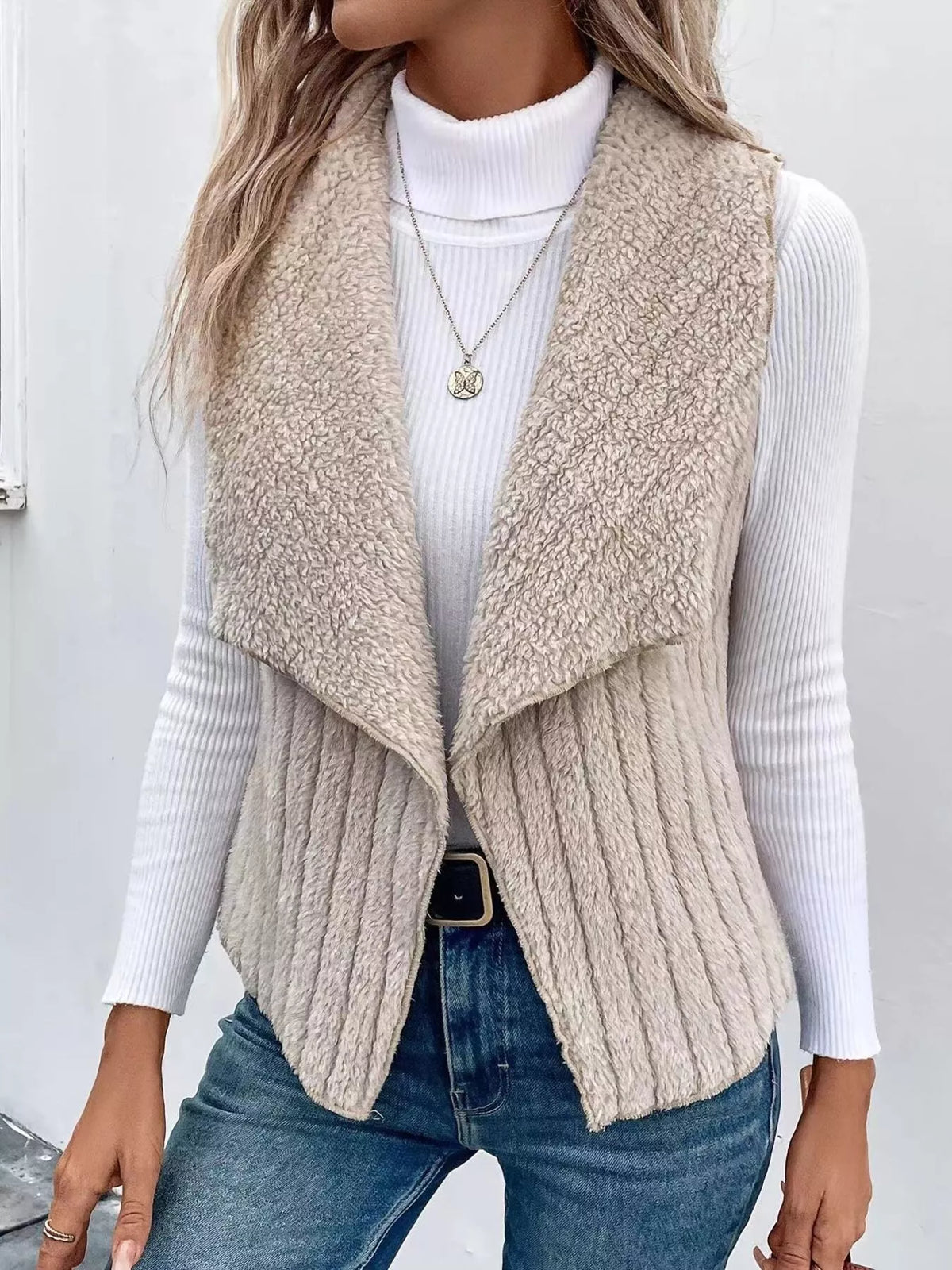 Cozy open front fleece vest in beige with a shawl collar, ribbed texture, and open sides.