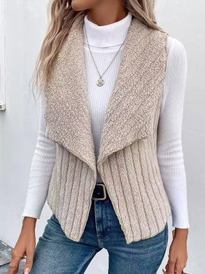 Cozy open front fleece vest in beige with a shawl collar, ribbed texture, and open sides.