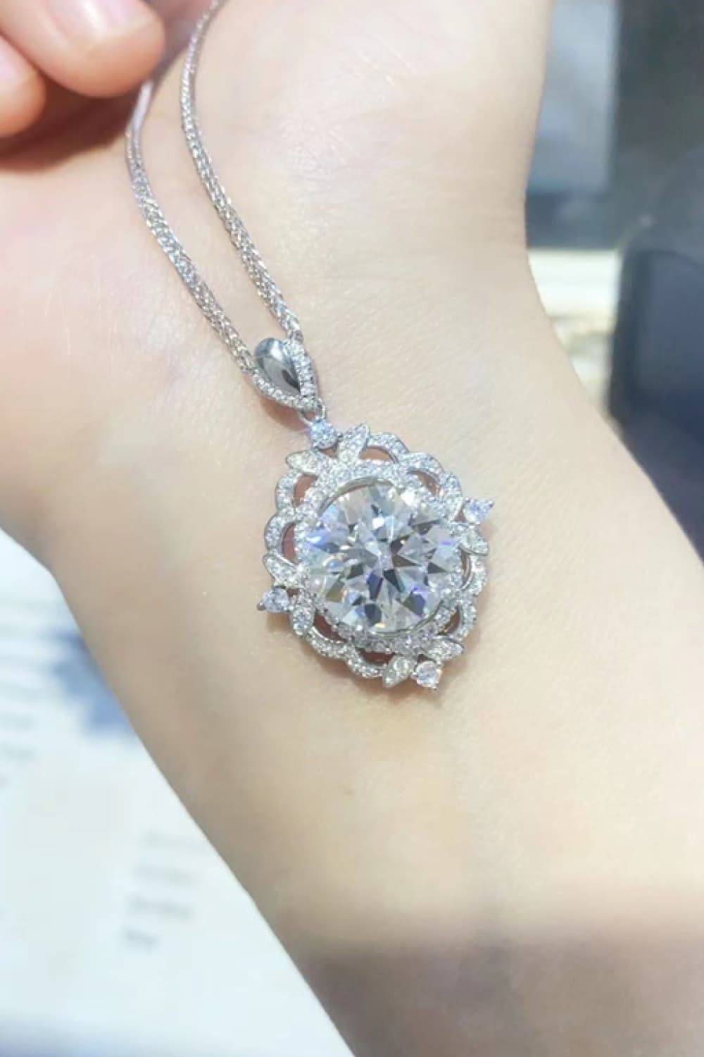Silver filigree halo diamond pendant necklace with intricate detailing.