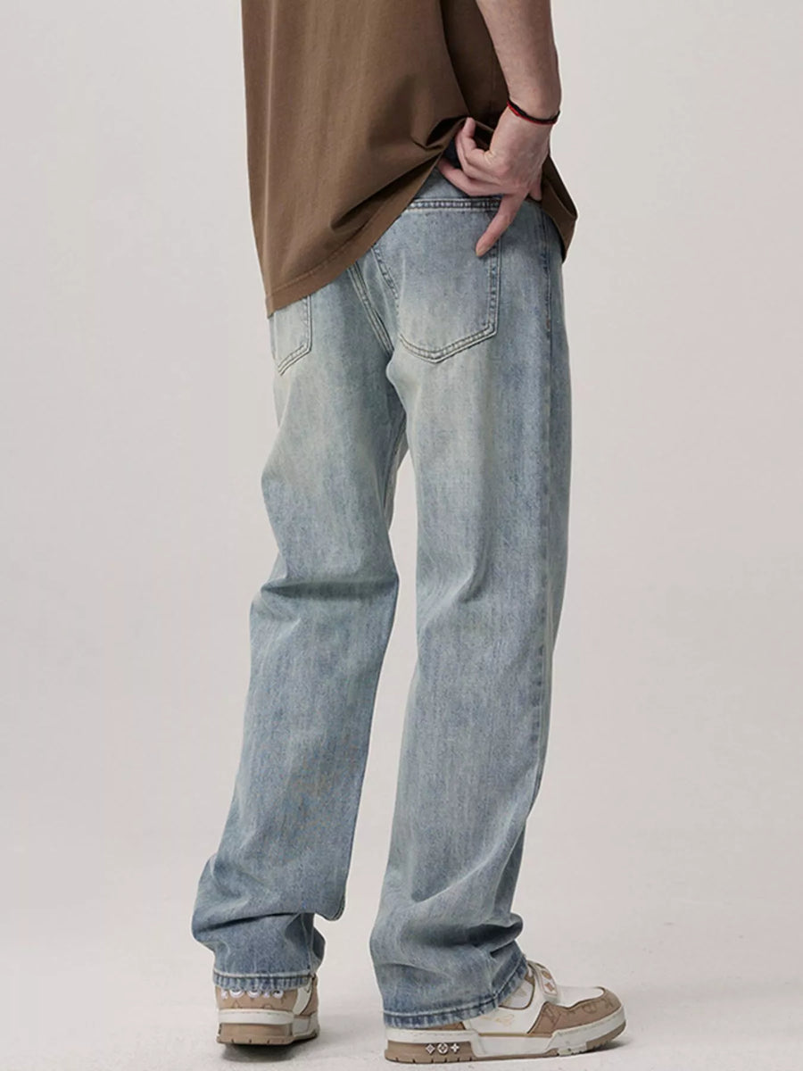 Men's light blue relaxed fit wash jeans with a distressed denim look.