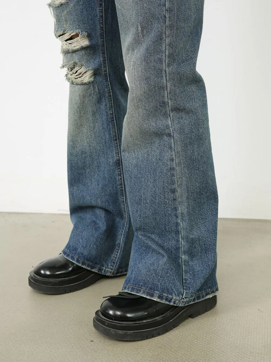 Distressed flare leg jeans in medium wash denim with ripped details