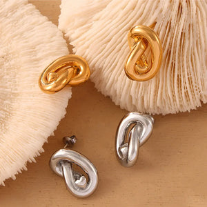Sculptural knot stud earrings in gold and silver with a chic, artistic design.