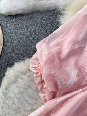 Pink chiffon maxi dress with floral embroidery and ruffled sleeve detail.