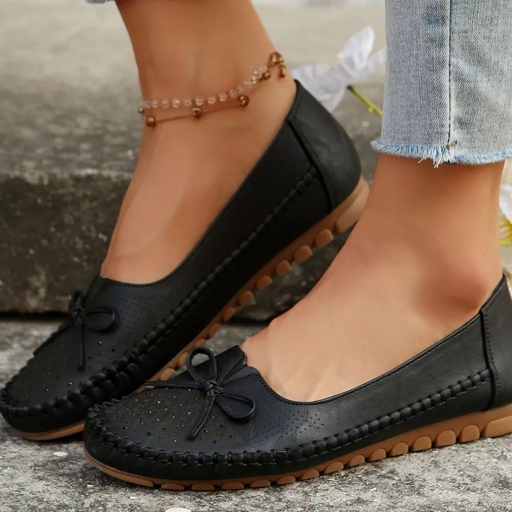 slip-ons in black featuring bow detail and regular fit