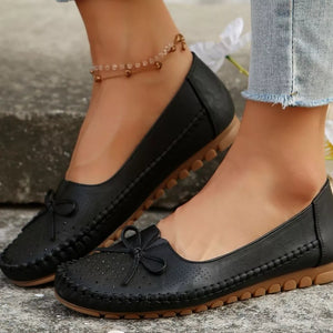 slip-ons in black featuring bow detail and regular fit