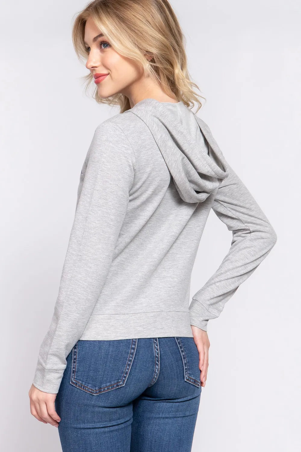 Grey graphic zip hoodie with a hood and long sleeves, worn with blue jeans.