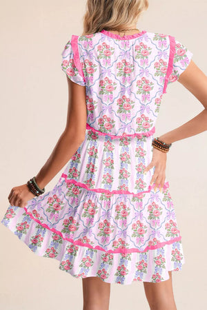 Floral tiered ruffle dress with bouquet and bow print, elastic waist, and pink trim.